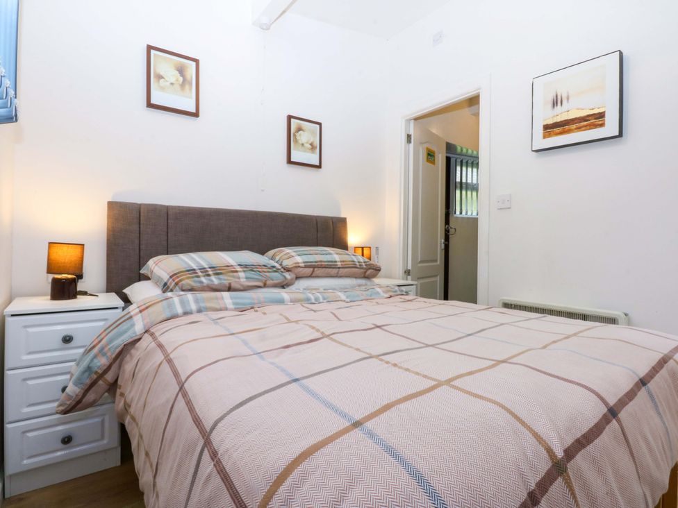 A bedroom with a bed and bedside table at River's Nook in Llangynog