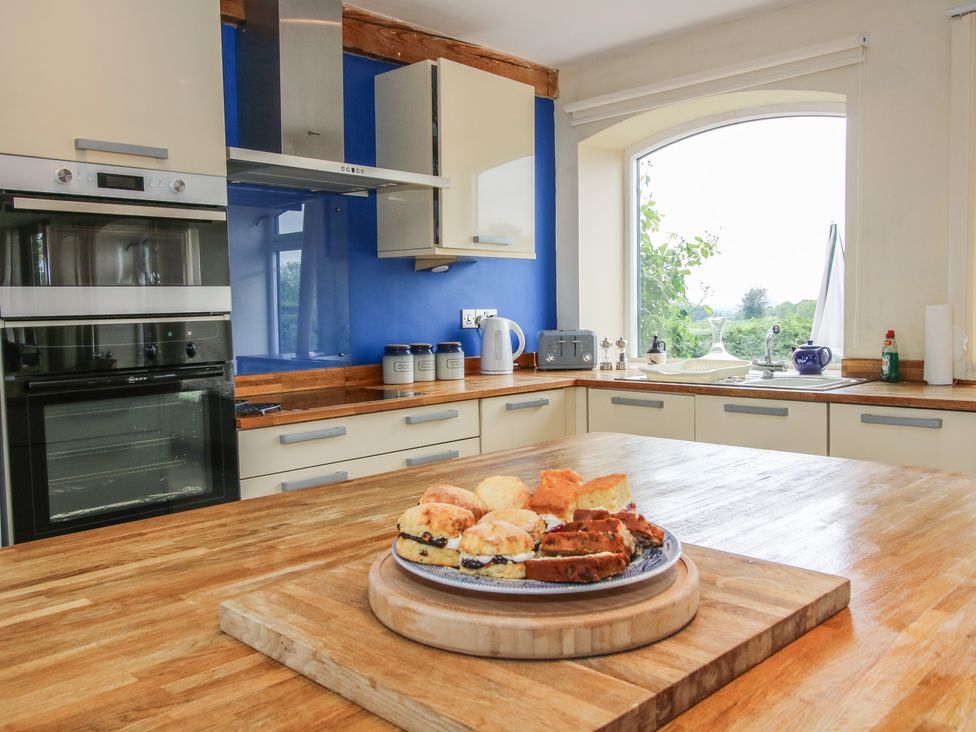 A kitchen with an oven, sink, and food on a table at The Oaks in Cockshutt near Ellesmere
