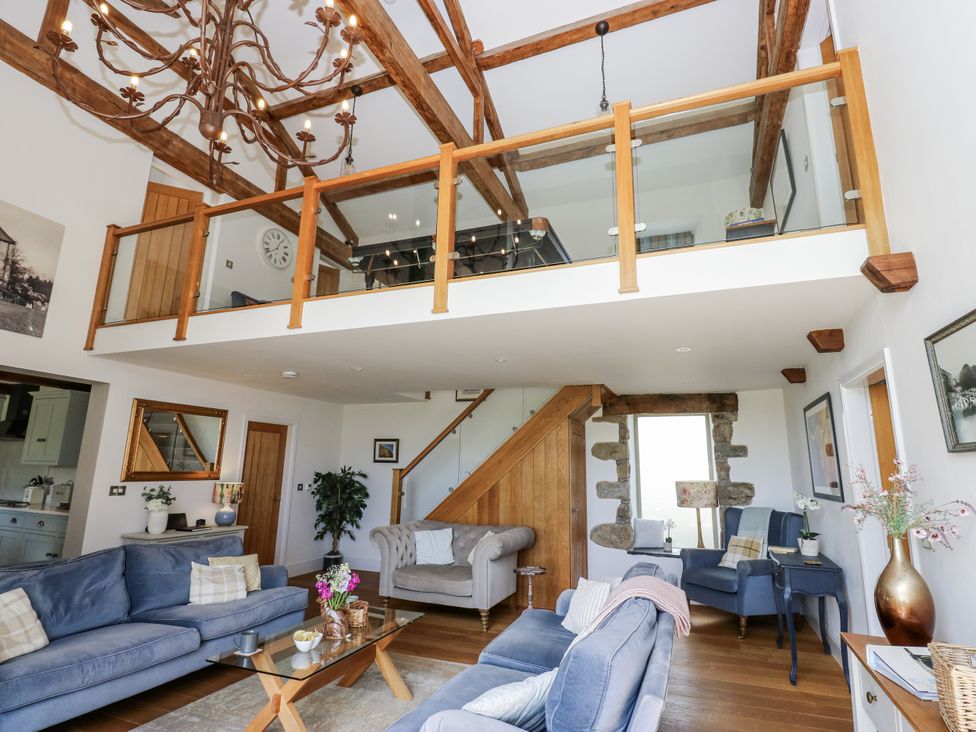 A living room with furniture and stairs at Crane Field Laithe in Otterburn, North Yorkshire