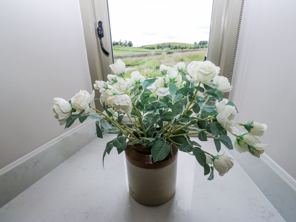 A flower pot with white flowers on a surface at Crane Field Laithe in Otterburn, North Yorkshire