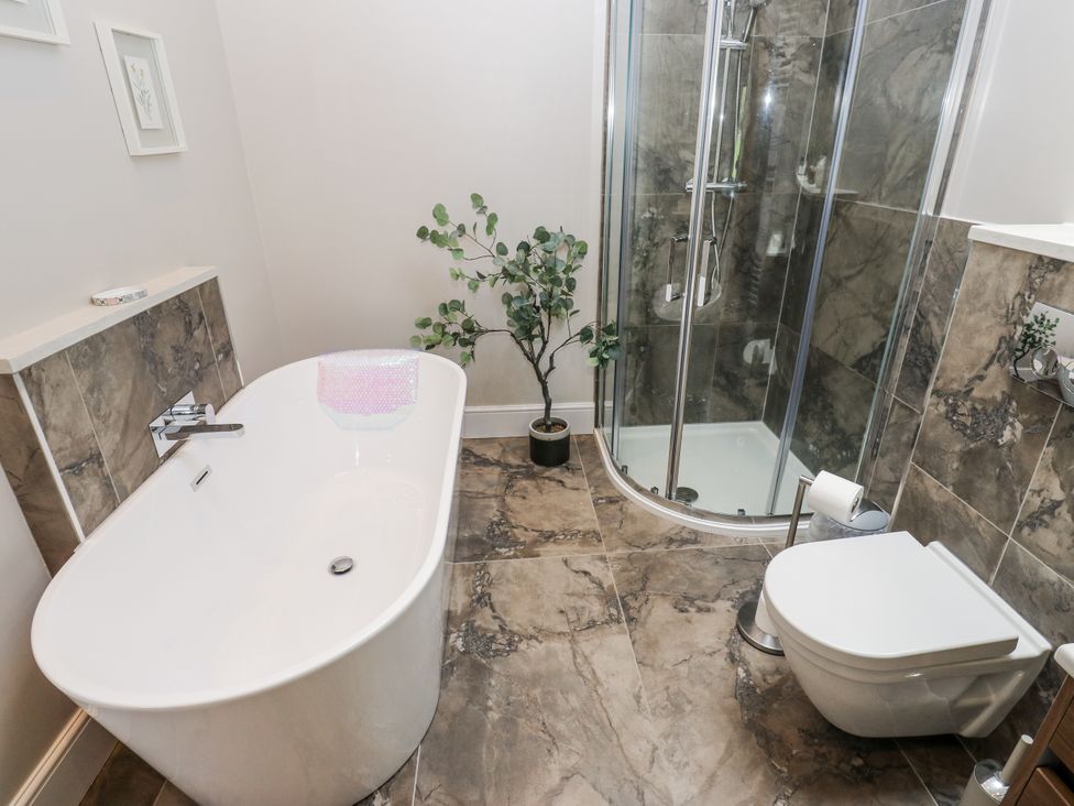 A bathroom with a bathtub and shower at Crane Field Laithe, Otterburn, North Yorkshire