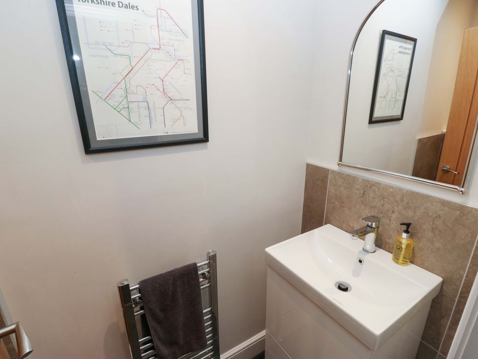 A bathroom with a sink and map on the wall at Crane Field Laithe, Otterburn, North Yorkshire