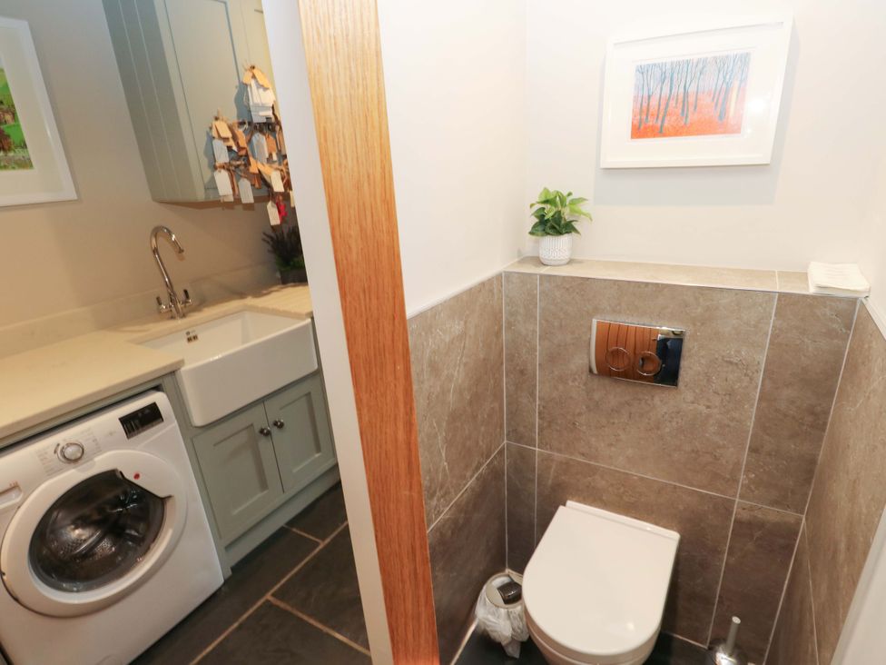 A bathroom with a sink and washing machine at Crane Field Laithe Otterburn, North Yorkshire