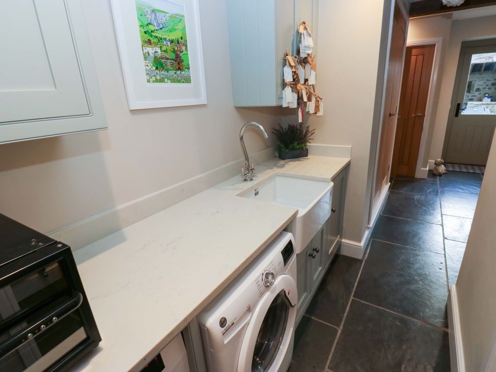 A laundry room with a washing machine and sink at Crane Field Laithe Otterburn, North Yorkshire