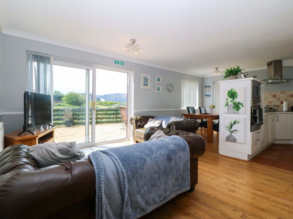 A living room with a sofa and television at Beach House (Ty Traeth) Deganwy