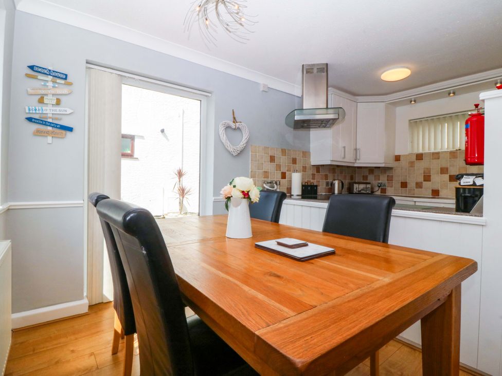 A dining room with a table and chairs at Beach House (Ty Traeth) Deganwy