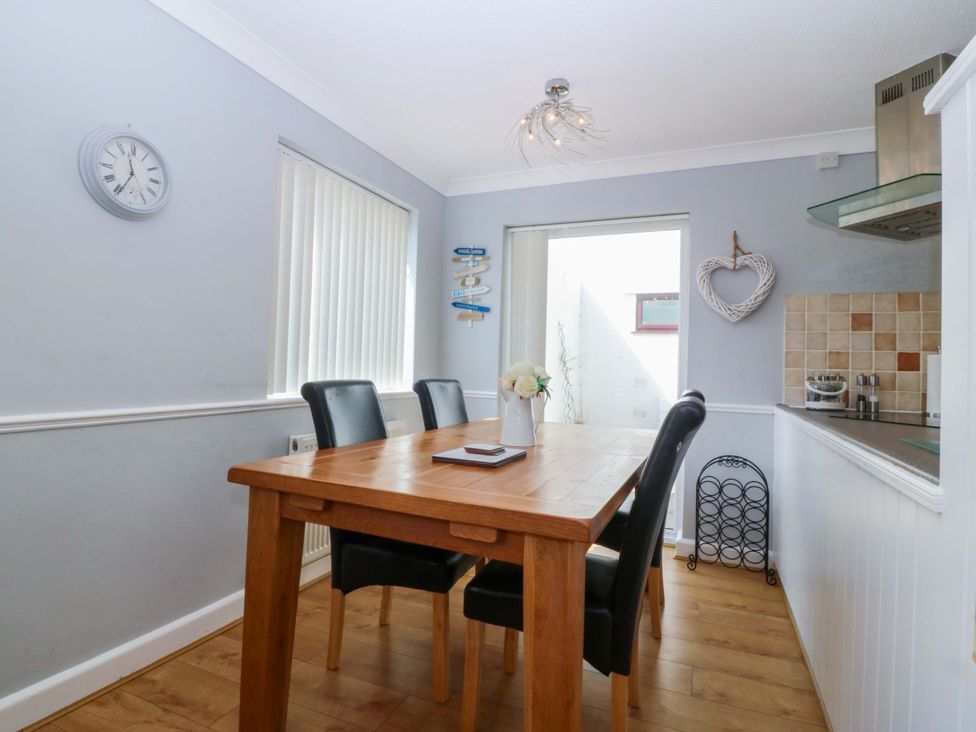 A dining room with a table and chairs at Beach House (Ty Traeth) Deganwy