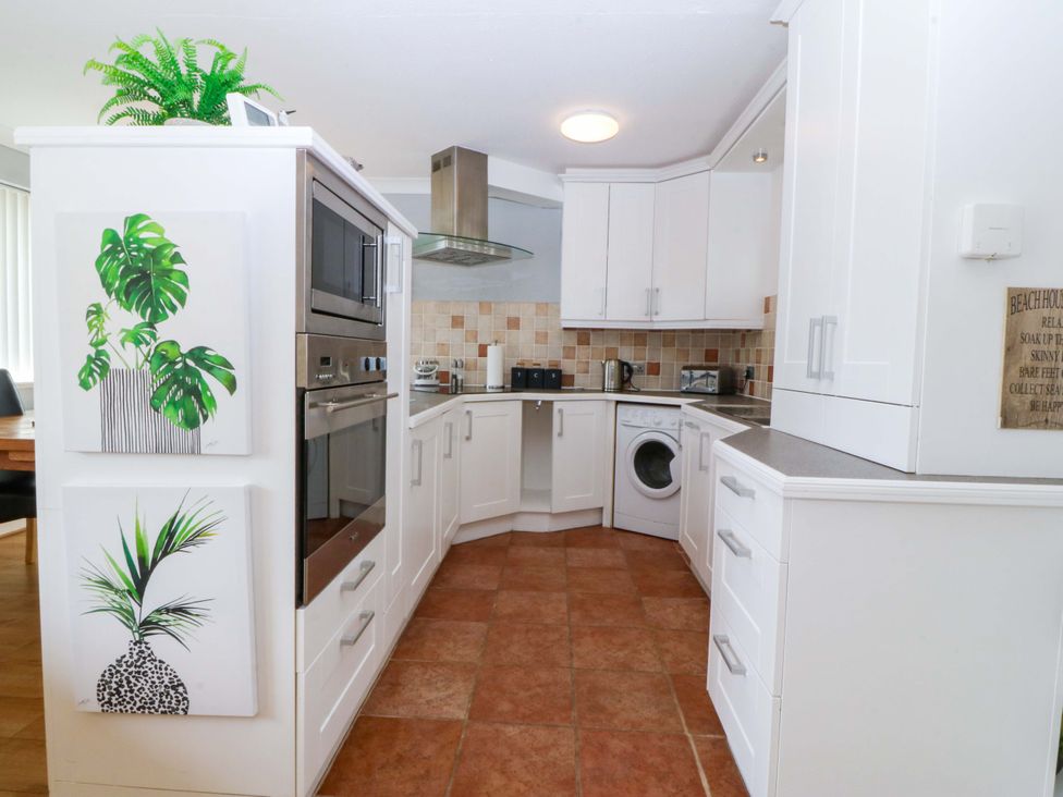 A kitchen with appliances and decorative art at Beach House (Ty Traeth) in Deganwy