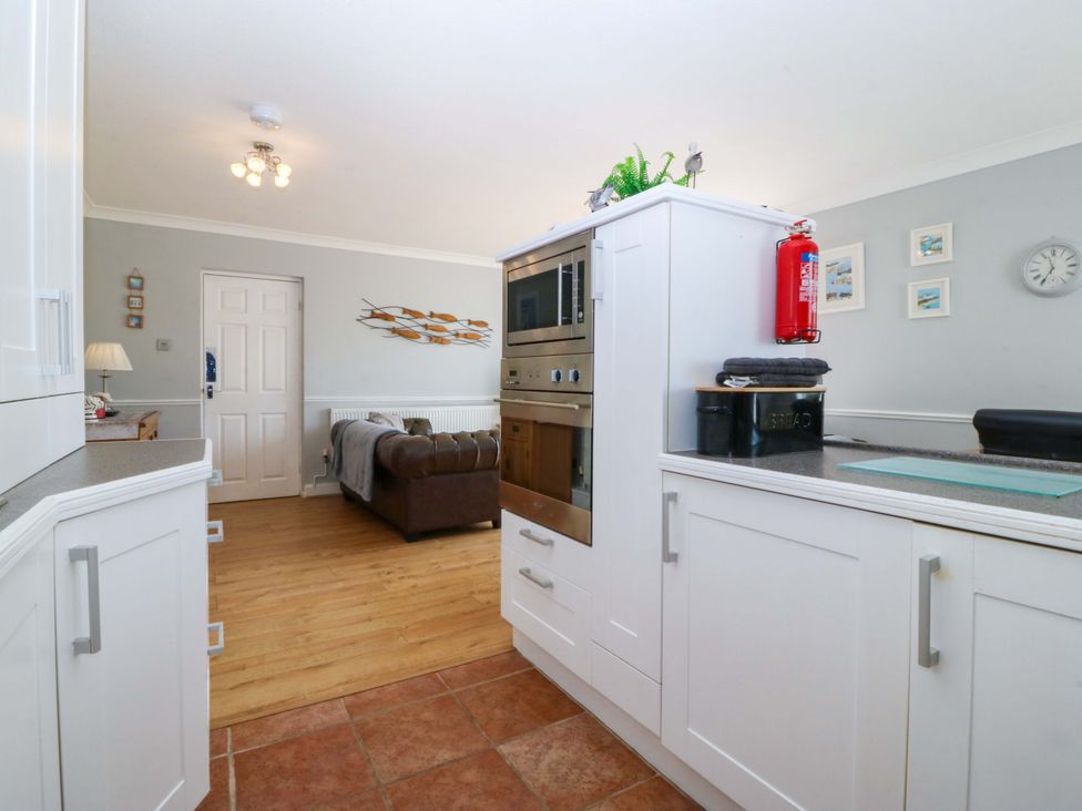 A kitchen with cupboards and an oven at Beach House (Ty Traeth) Deganwy