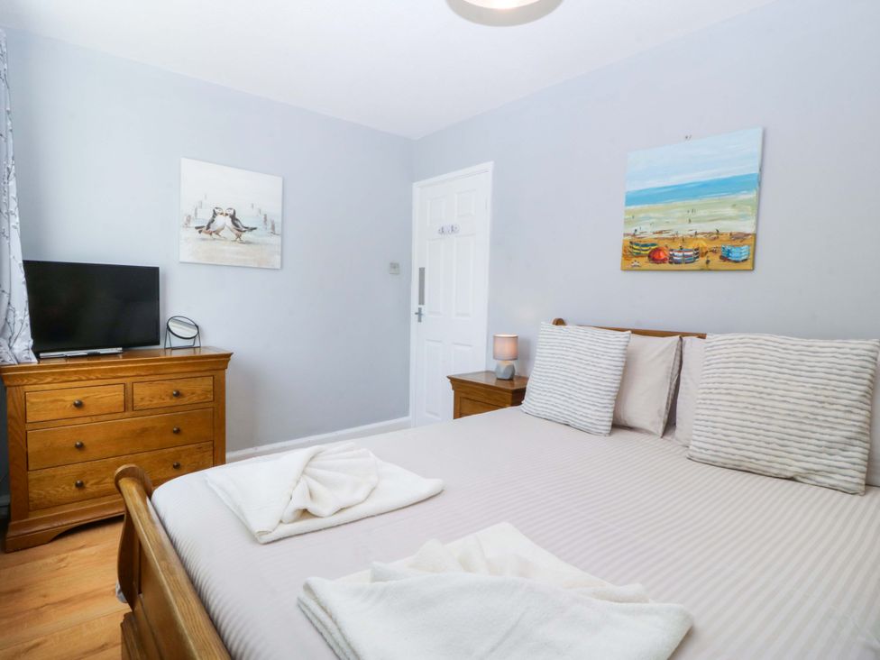 A bedroom with a bed and furniture at Beach House (Ty Traeth) Deganwy