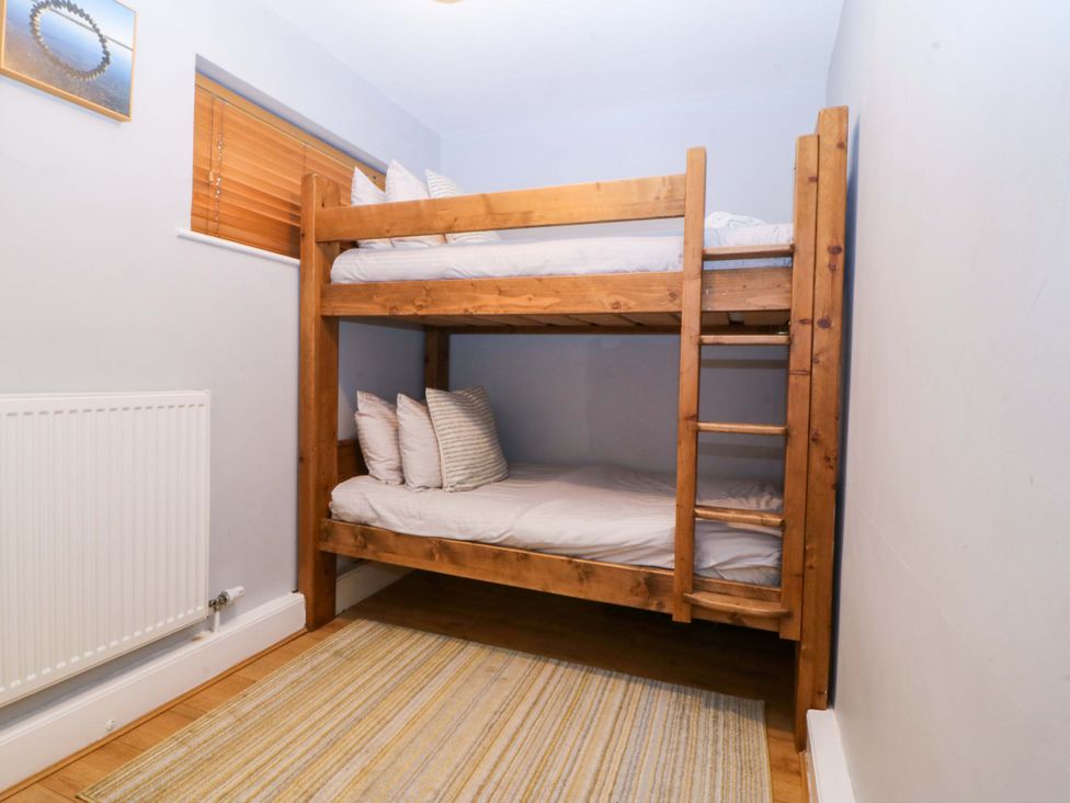 A bunk bed with pillows in a bedroom at Beach House (Ty Traeth) Deganwy