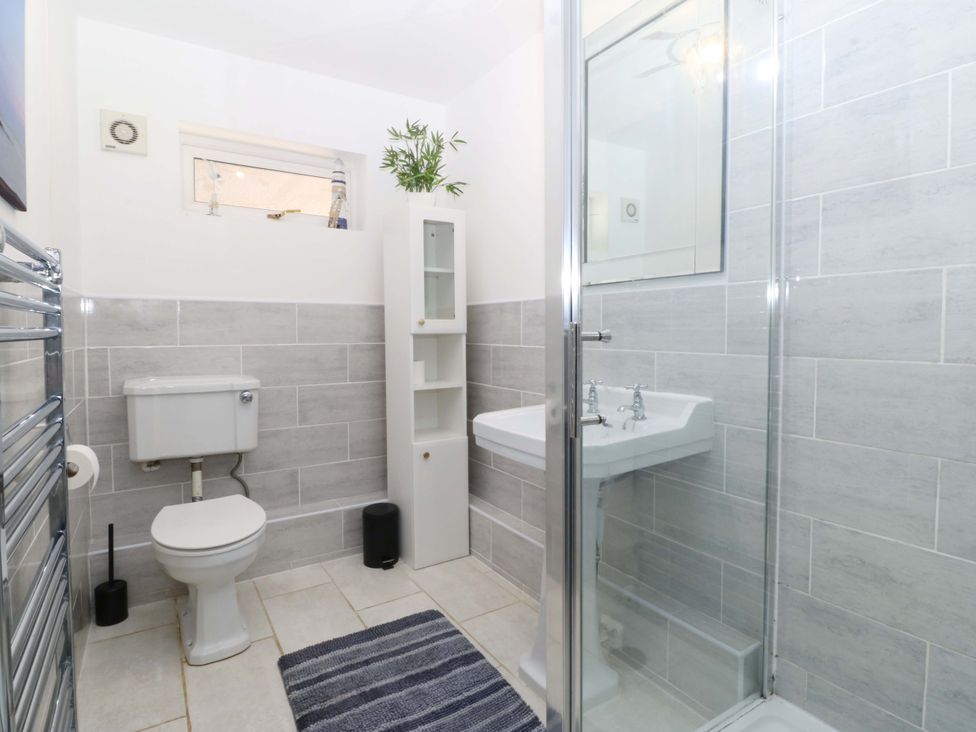 A bathroom featuring a shower, sink, and toilet at Beach House (Ty Traeth) Deganwy