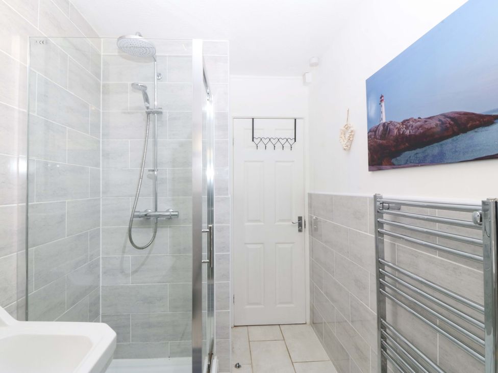 A bathroom with a shower and towel radiator at Beach House (Ty Traeth) Deganwy