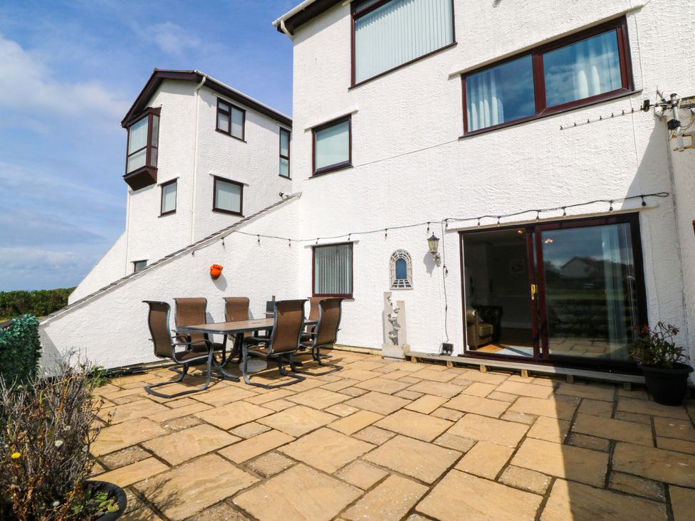An outdoor seating area with a table and chairs at Beach House (Ty Traeth) Deganwy
