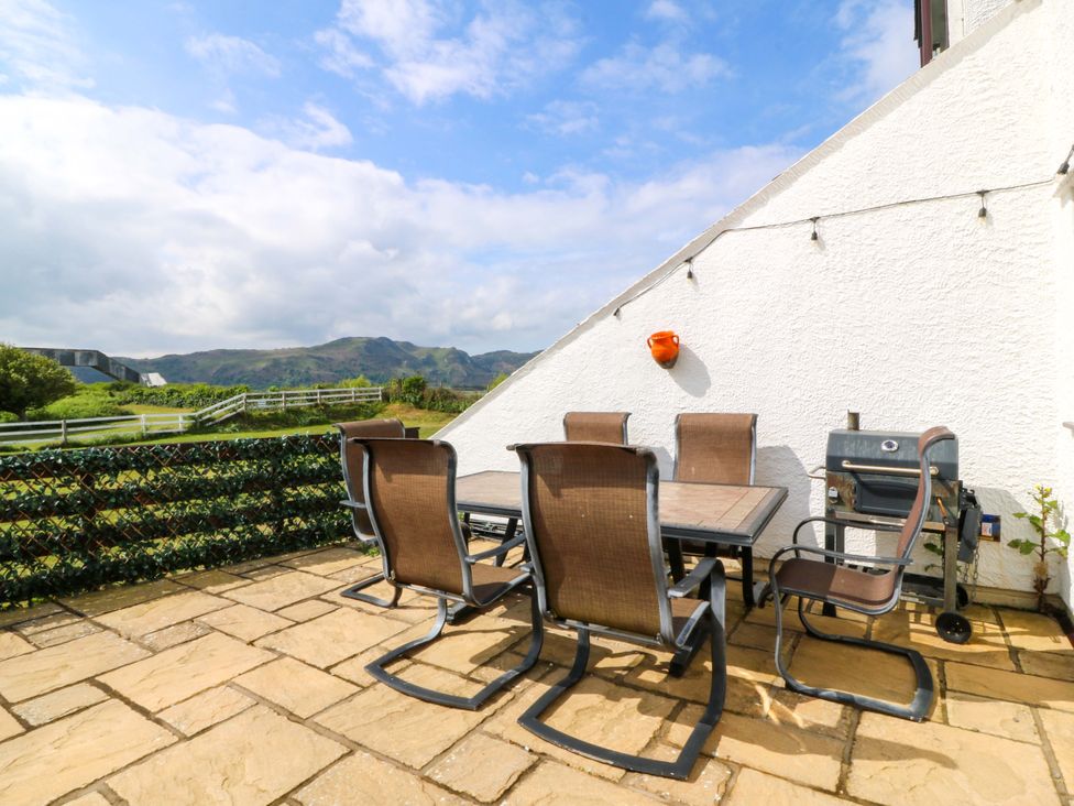 An outdoor patio with a table and chairs at Beach House (Ty Traeth) Deganwy