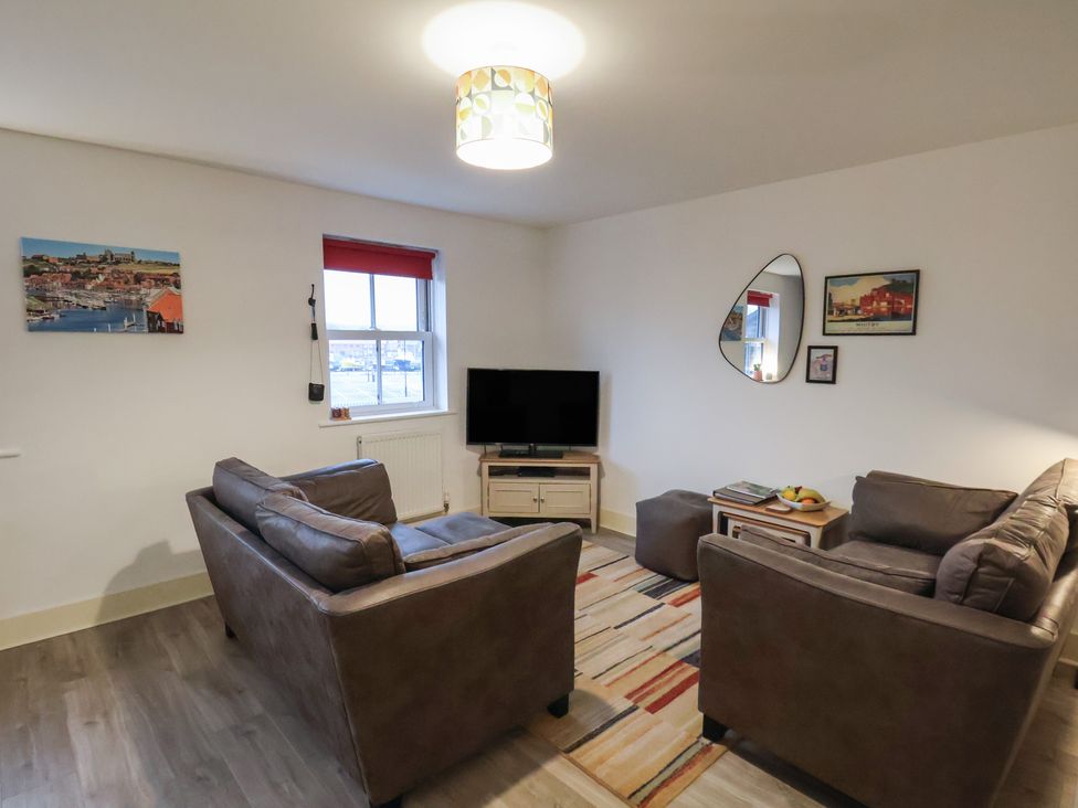 A living room with sofas and a television at All Aboard in Whitby