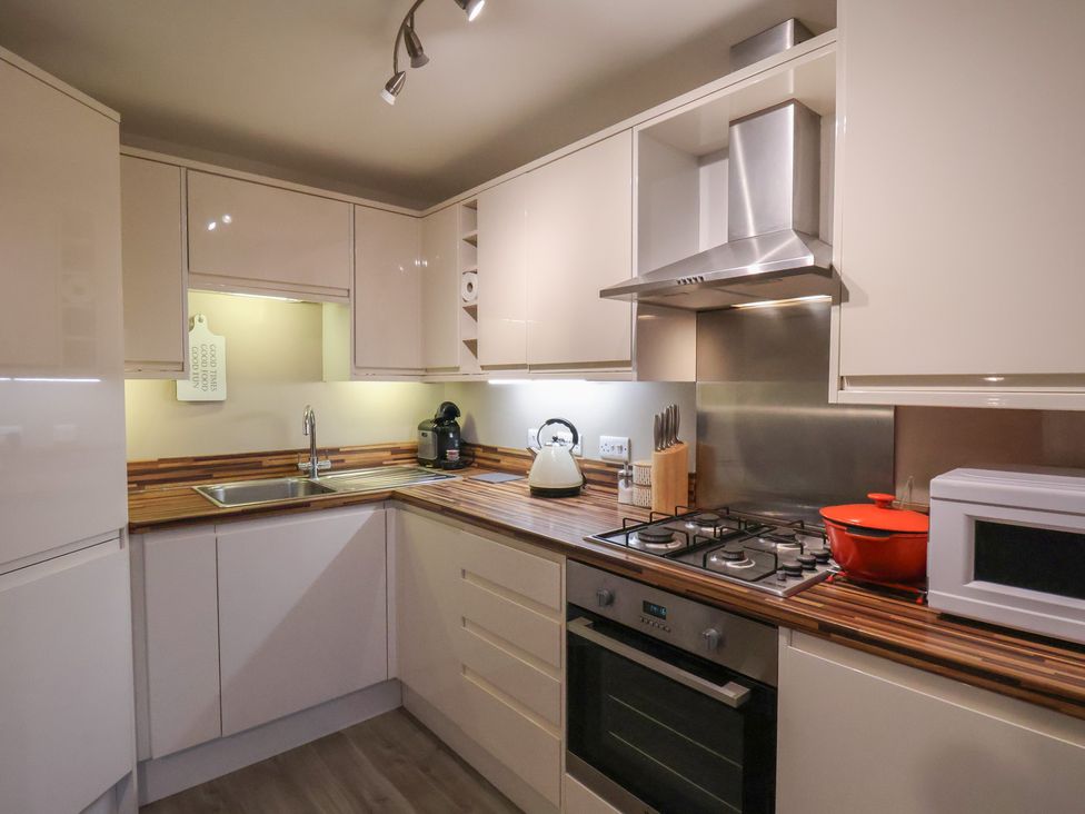 A kitchen with cabinetry, sink, stove, and microwave at All Aboard in Whitby