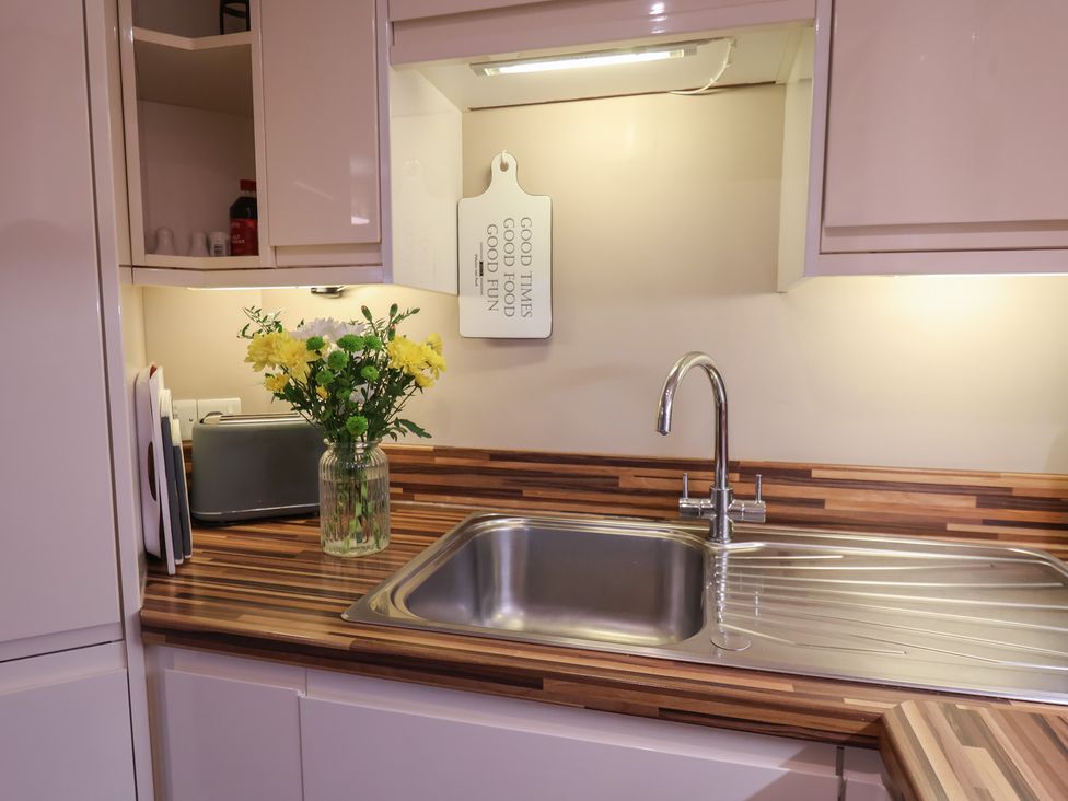 A kitchen with a sink and flower vase at All Aboard in Whitby