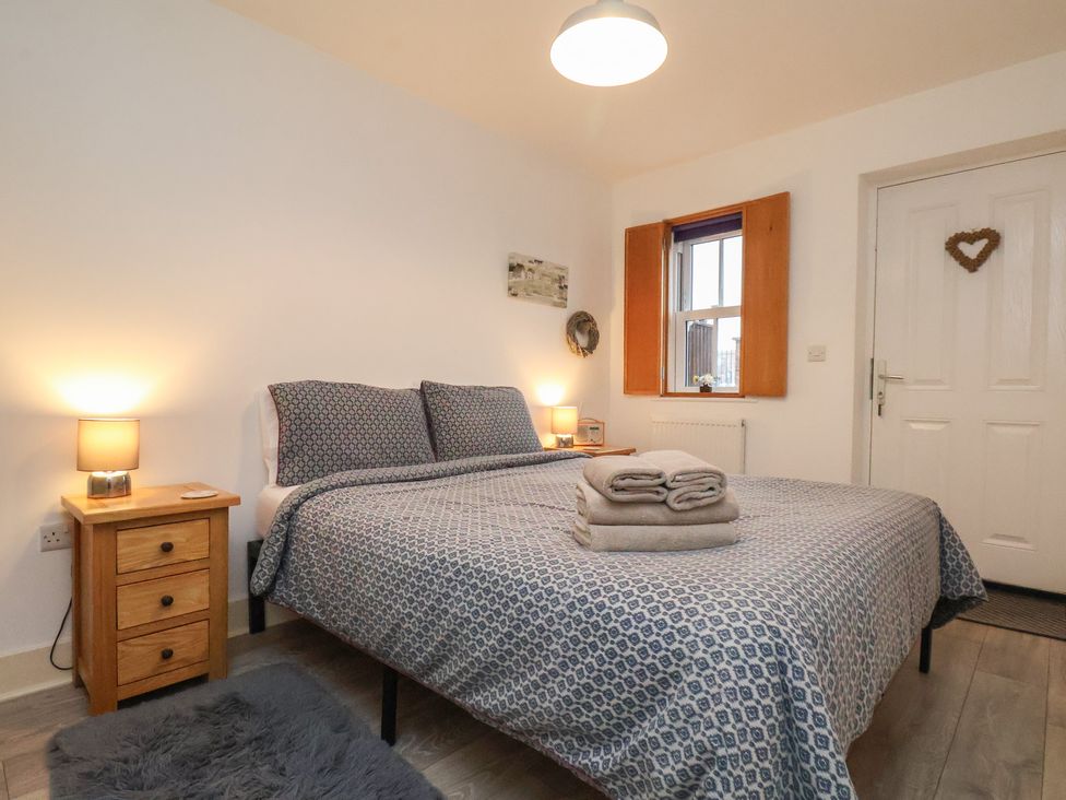 A bedroom with a double bed and bedside table at All Aboard in Whitby