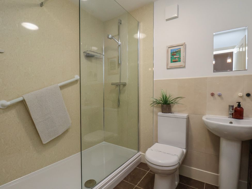 A bathroom with a shower, toilet, and sink at All Aboard in Whitby