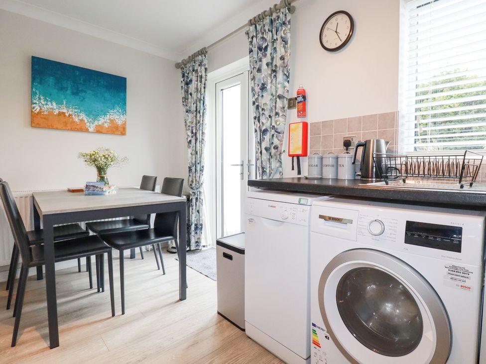 A kitchen with a table and chairs at Gull Cottage in Padstow