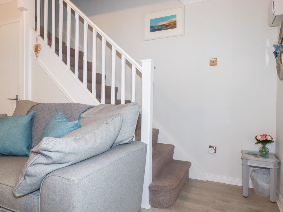 A living room with a sofa and stairs at Gull Cottage in Padstow