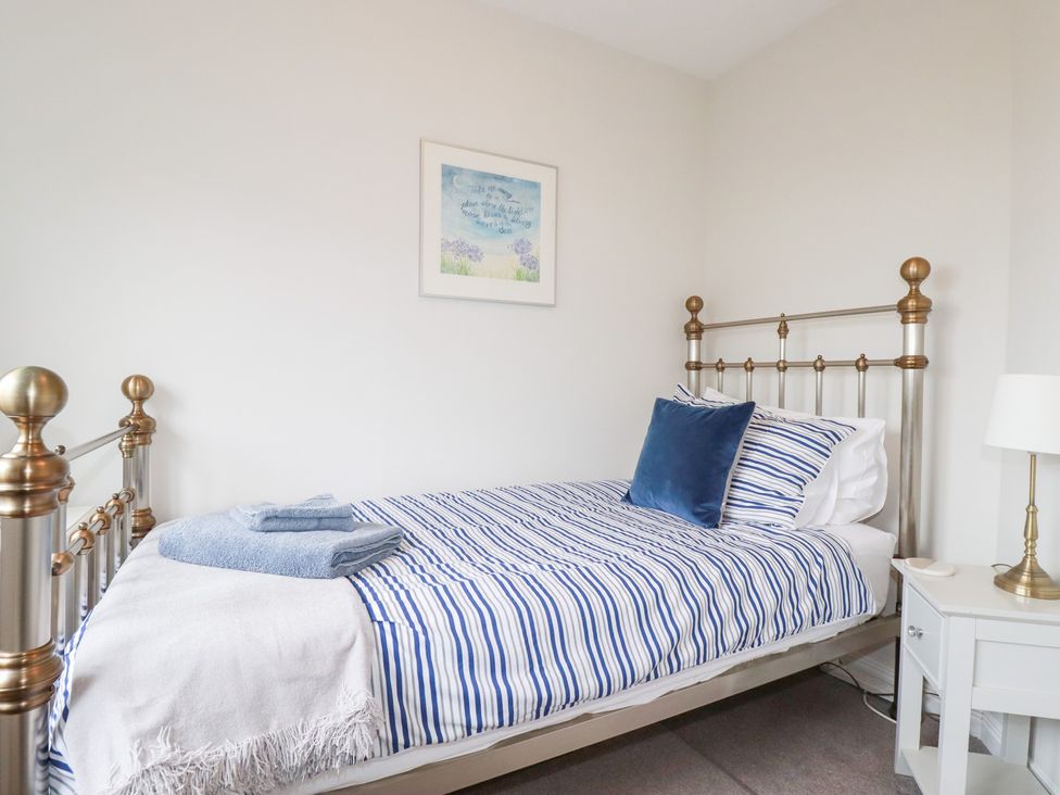 A bedroom with a single bed and nightstand at Gull Cottage in Padstow