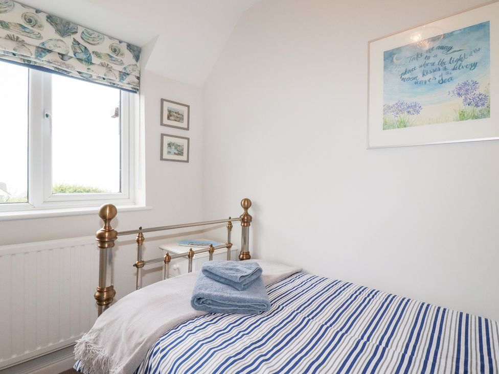 A bedroom with a bed and decorative art at Gull Cottage in Padstow
