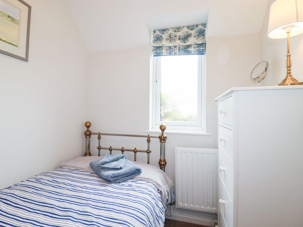 A bedroom with a bed and dresser at Gull Cottage in Padstow