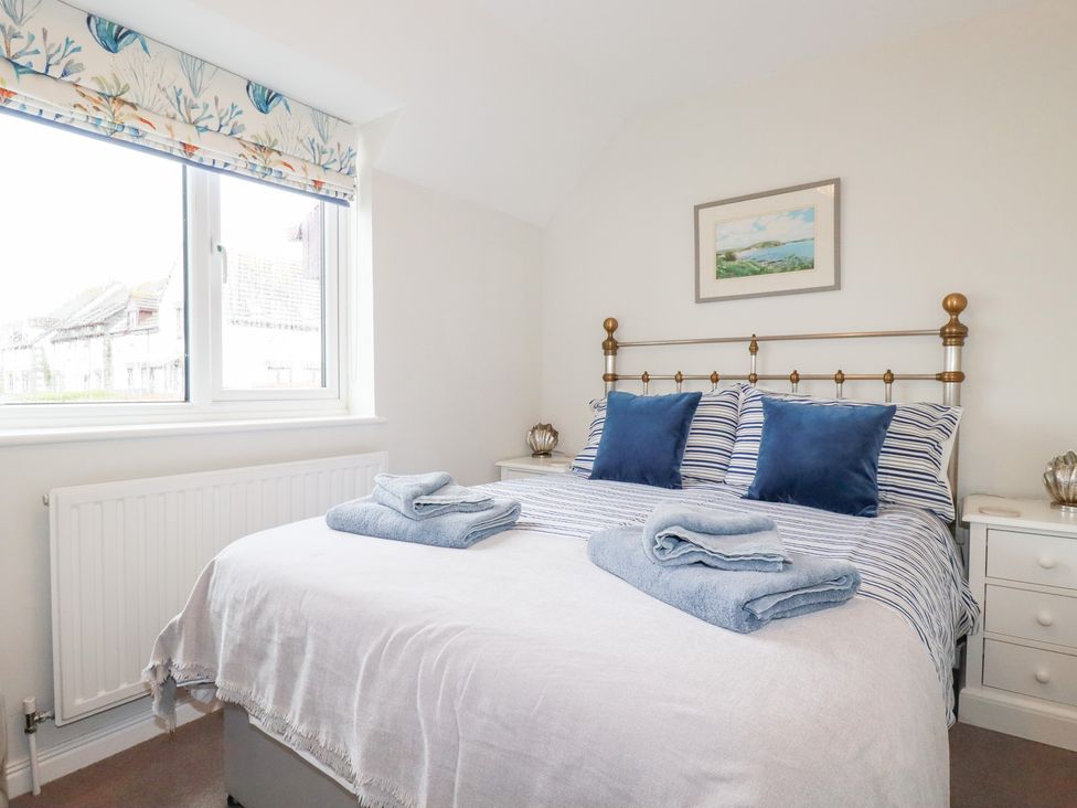 A bedroom with a bed and bedside table at Gull Cottage in Padstow