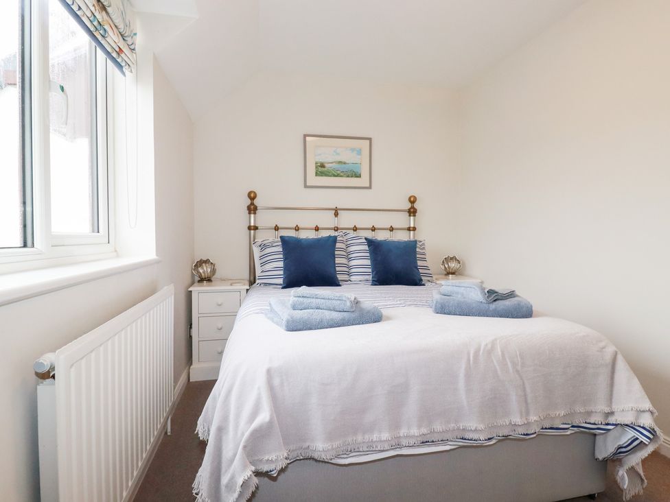 A bedroom with a bed and bedside table at Gull Cottage in Padstow