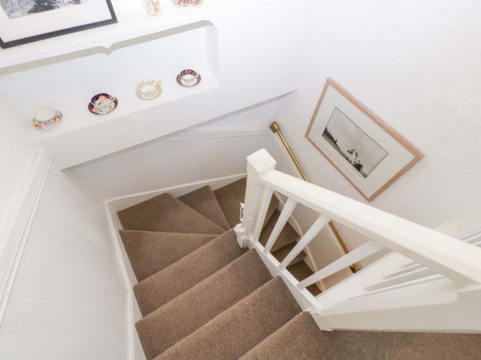 A staircase with a handrail and decorative plates at 7 Bell Street in Talgarth