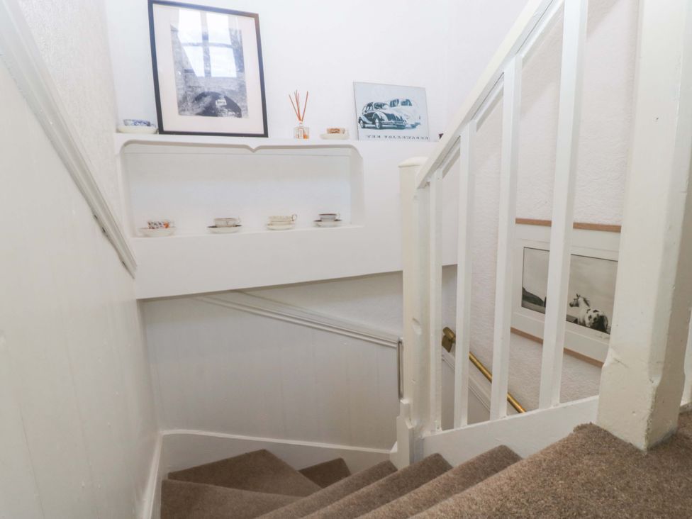 A staircase with shelf and pictures at 7 Bell Street Talgarth