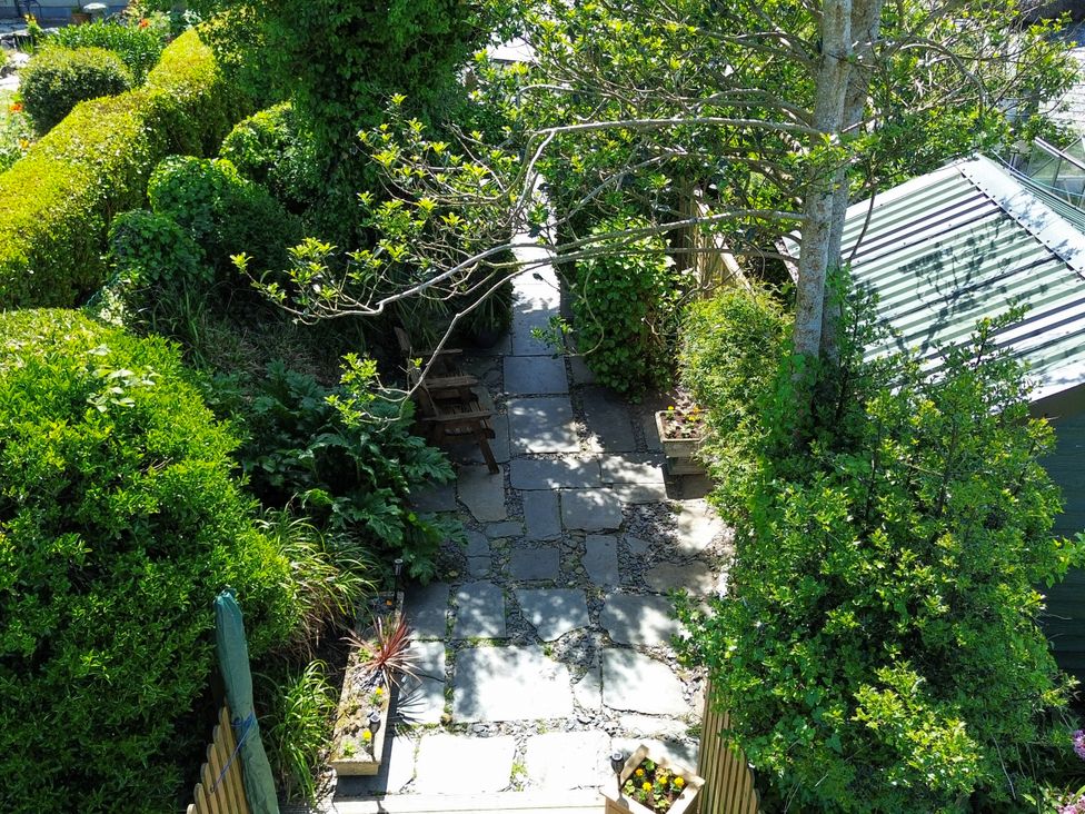 A garden pathway framed by hedges and plants at Easterly Cottage Bude