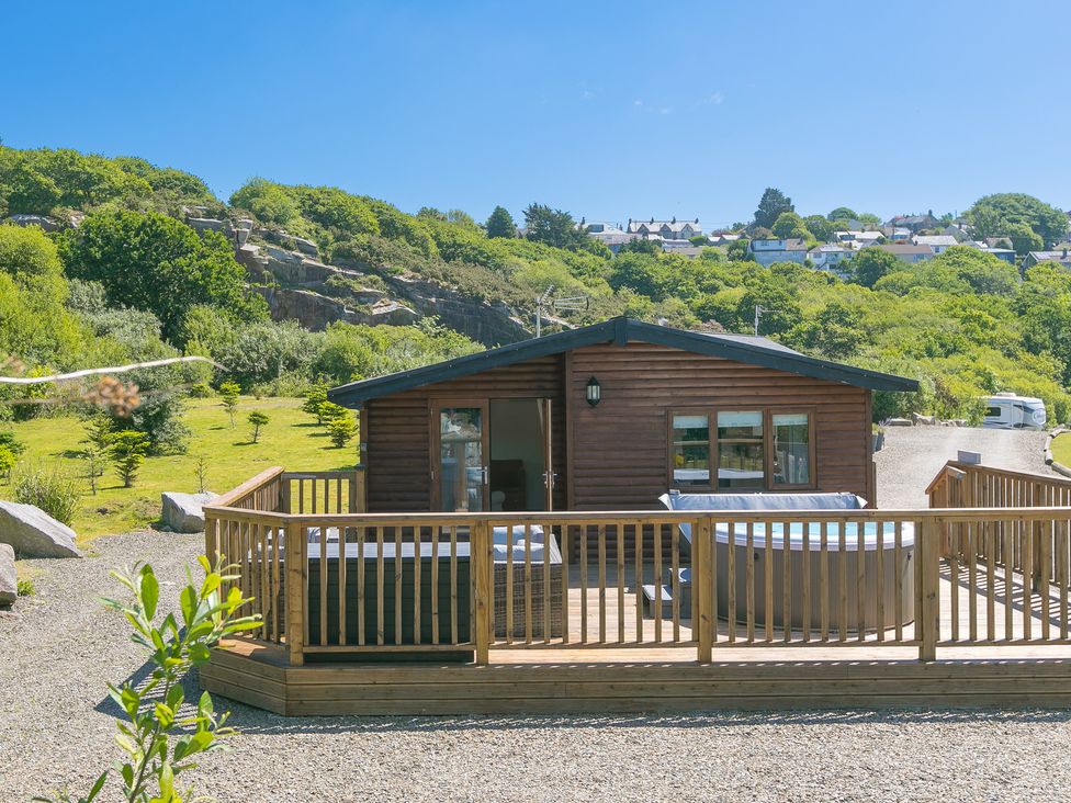 A cabin with a deck and hot tub at Costentyn, Tor Down Quarry in St Breward