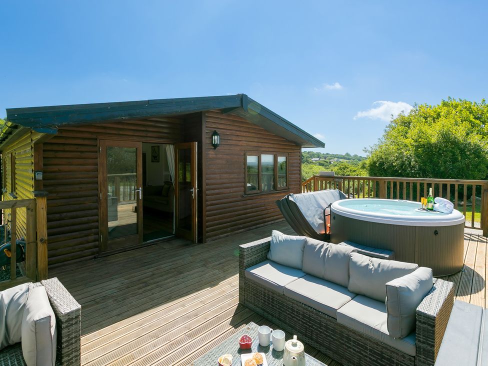 An outdoor area with a hot tub and seating at Costentyn, Tor Down Quarry St Breward