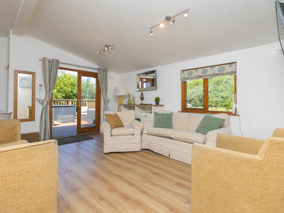 A living room with a sofa and armchairs at Costentyn, Tor Down Quarry in St Breward