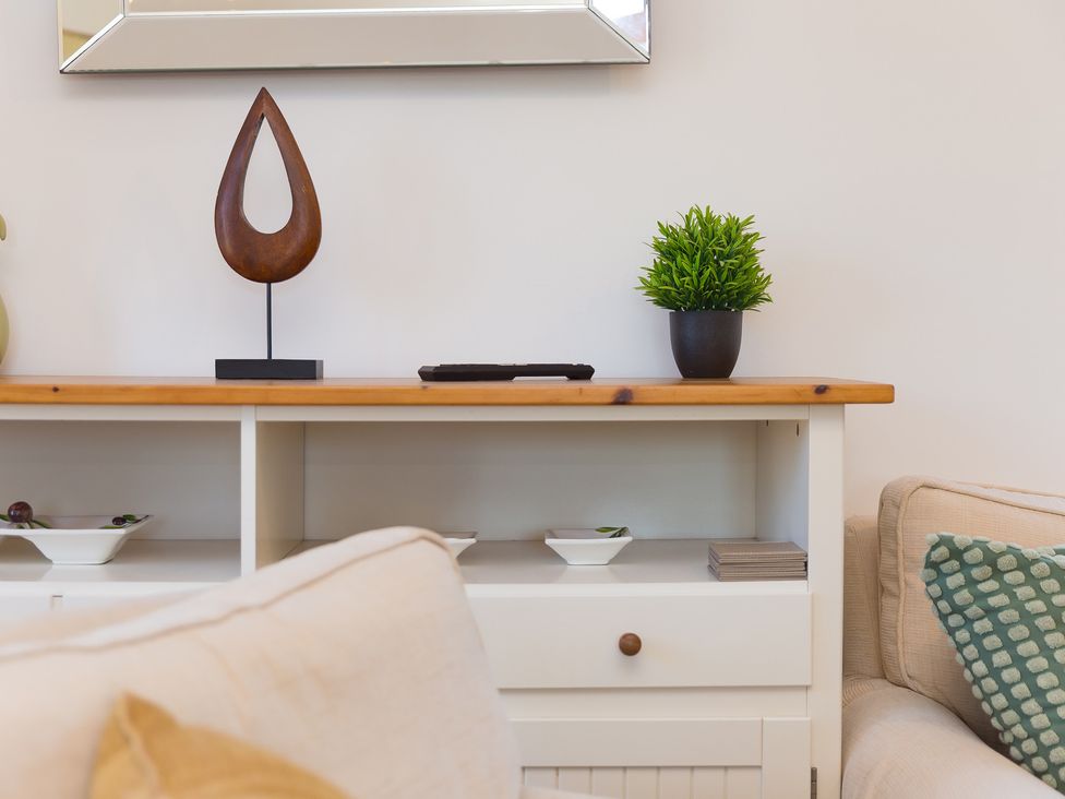 A living room with a shelf displaying a plant and sculpture at Costentyn, Tor Down Quarry St Breward
