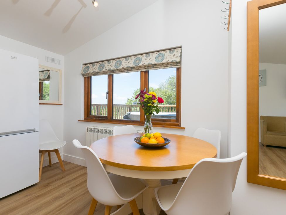 A dining room with a table and chairs at Costentyn, Tor Down Quarry St Breward