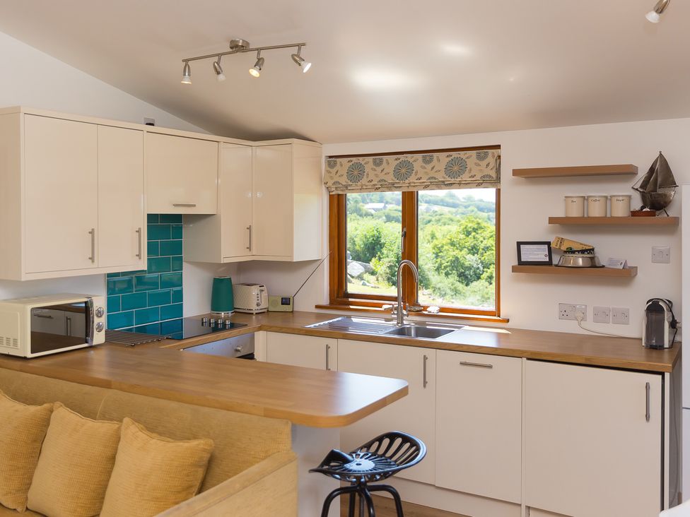 A kitchen with wooden countertop and window at Costentyn, Tor Down Quarry in St Breward
