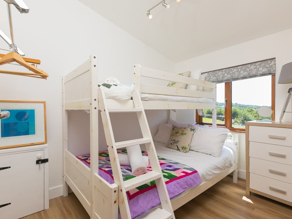 A bedroom with a bunk bed and multiple furniture at Costentyn, Tor Down Quarry St Breward
