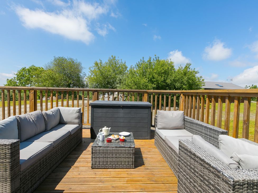 An outdoor seating area with sofas and a coffee table at Costentyn, Tor Down Quarry St Breward