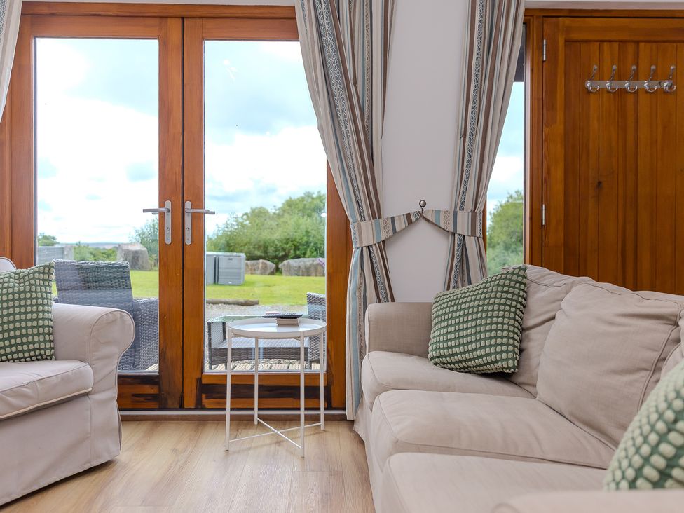 A living room with a sofa and table at Tressa, Tor Down Quarry St Breward