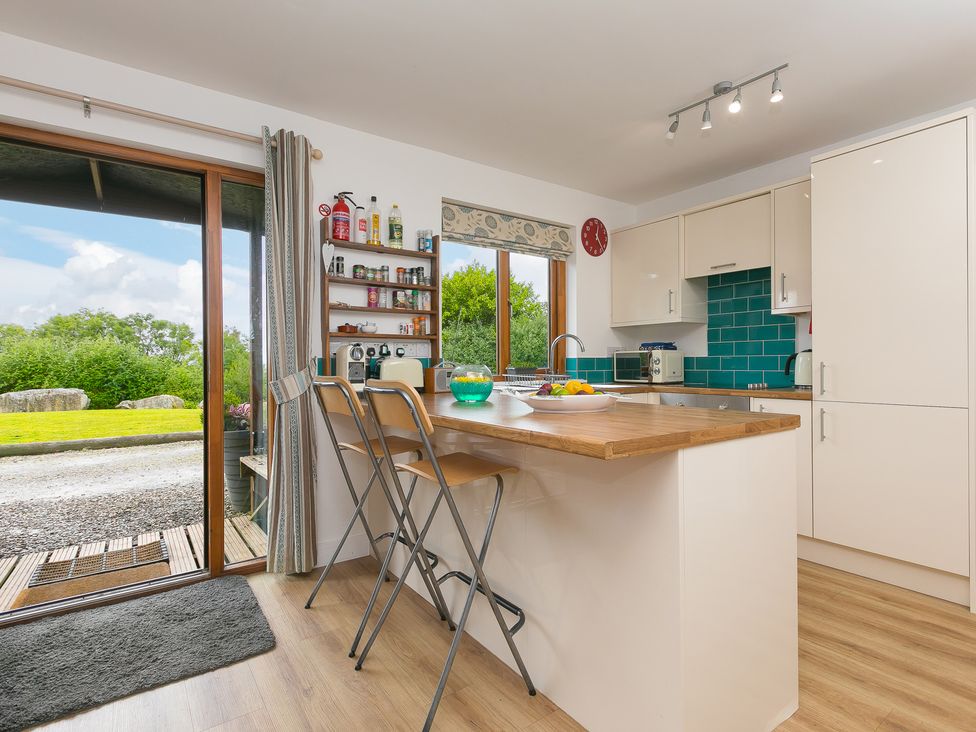 A kitchen with countertop and bar stools at Tressa, Tor Down Quarry in St Breward