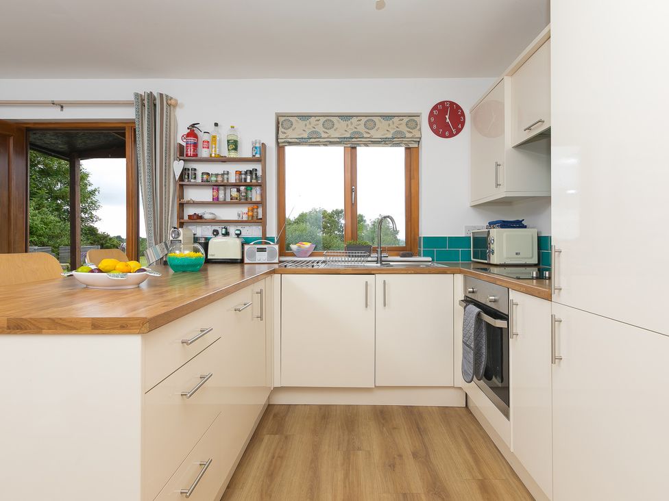 A kitchen with a sink, counter, and shelves at Tressa, Tor Down Quarry St Breward