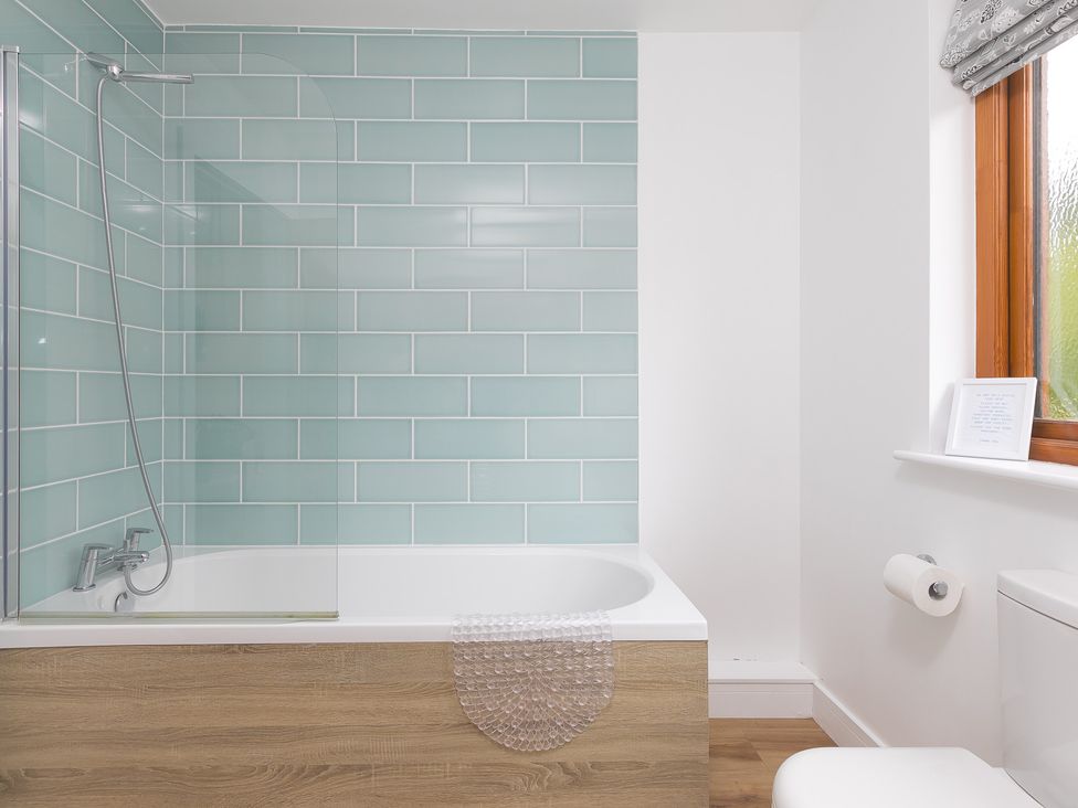 A bathroom with a bathtub and shower at Tressa, Tor Down Quarry in St Breward