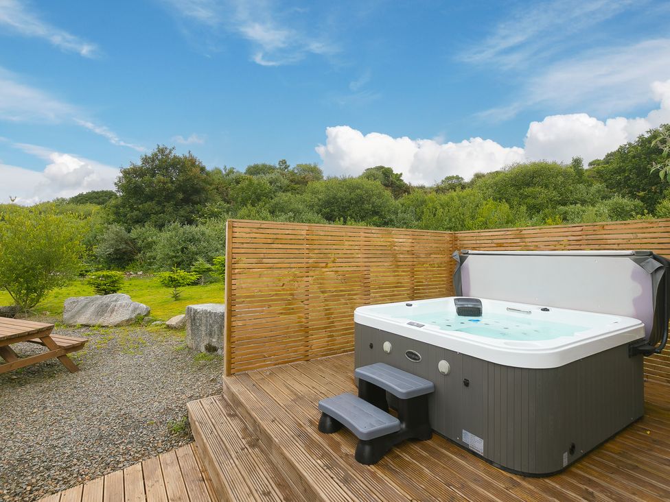 An outdoor area with a hot tub and wooden decking at Tressa, Tor Down Quarry in St Breward