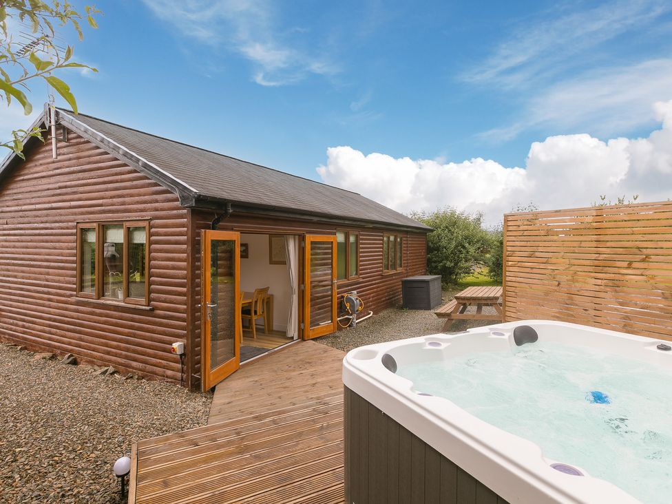 An outdoor area with a hot tub and seating at Tressa, Tor Down Quarry in St Breward