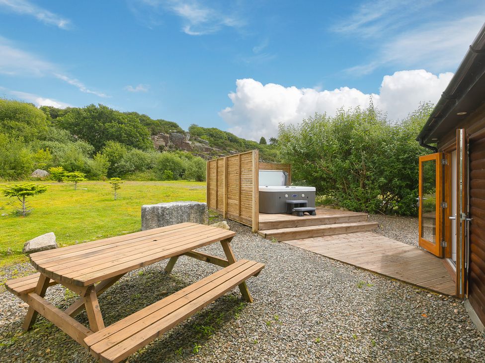 An outdoor area with a picnic table and hot tub at Tressa, Tor Down Quarry, St Breward