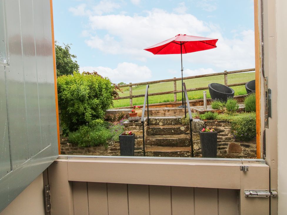 An outdoor area view with steps and an umbrella at The Hay Loft in Craven Arms